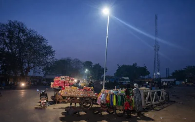 Solar street light illuminating evening street vendors in Wukari Nigeria, helping small businesses operate at night
